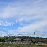 Maison aux volets bleus adossée à la colline, calme absolu au milieu des champs